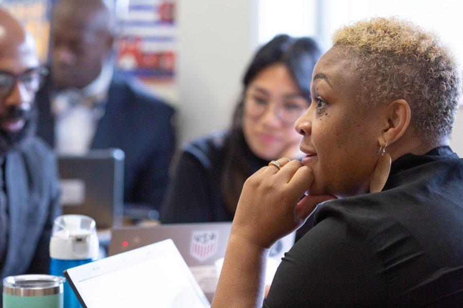 A middle school teacher listens during a team planning session.