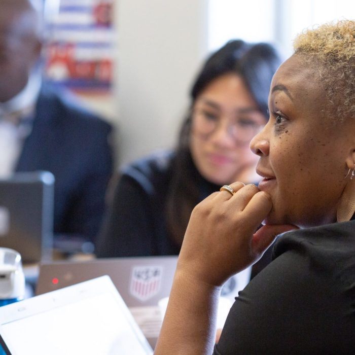 A middle school teacher listens during a team planning session.