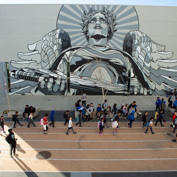 Students at UCLA Community School pass by one of several outdoor campus murals on their way to class.